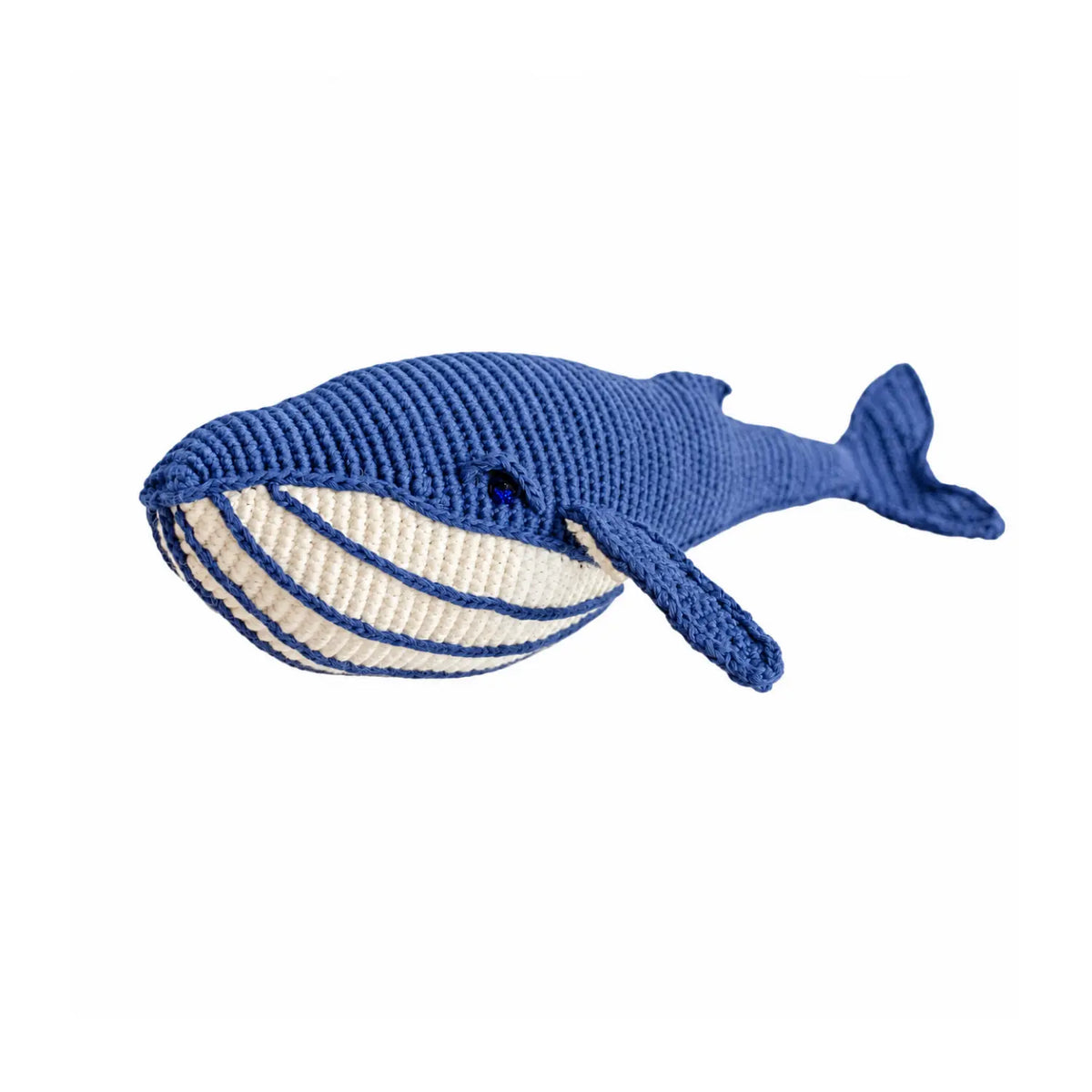 Deep blue crochet whale soft toy tilted to show its cream belly with blue stripes and its curved tail