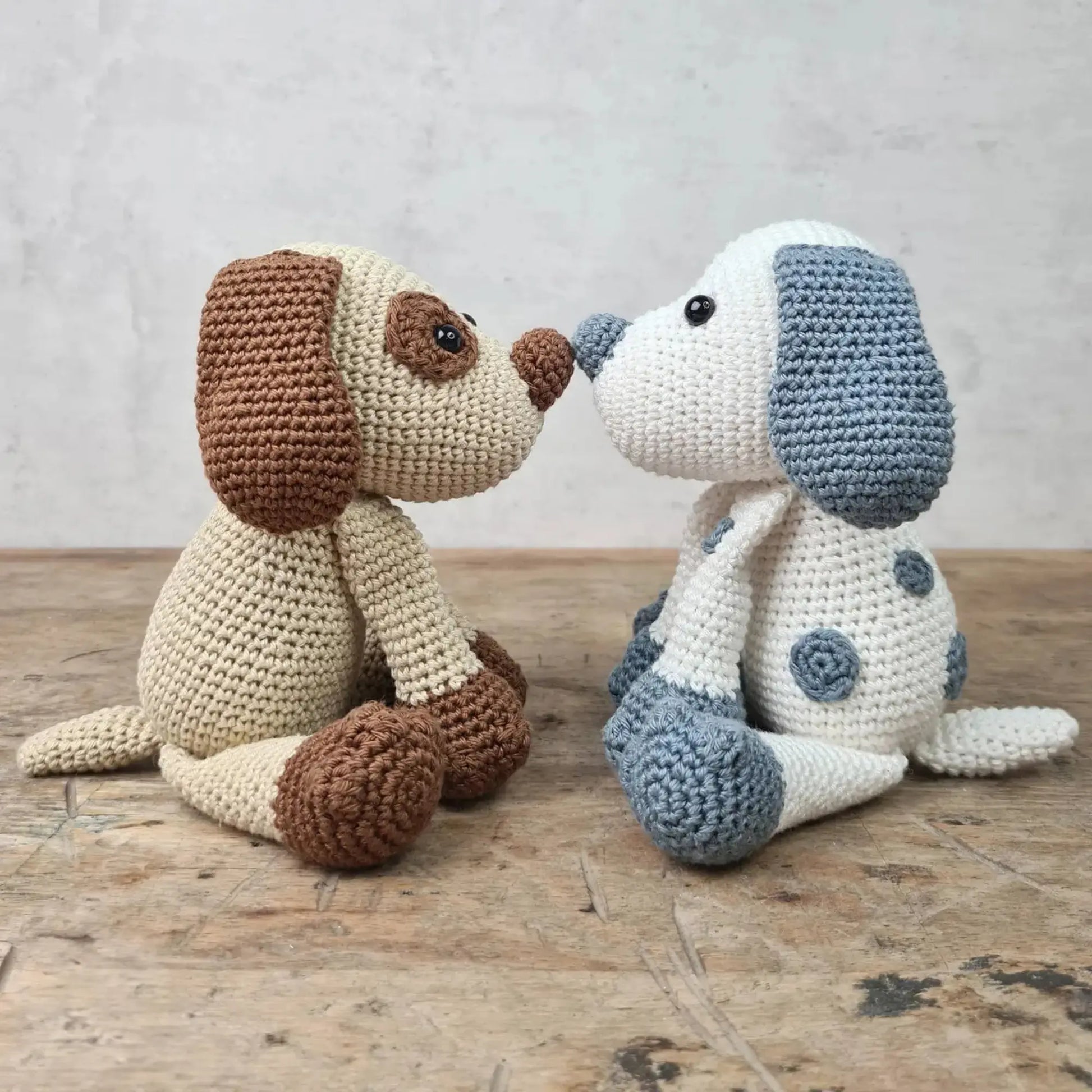Two finished crocheted puppy stuffed animals showing tan and blue color options