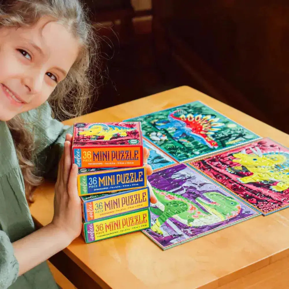 Child with mini puzzle boxes and colorful puzzle pieces on a table
