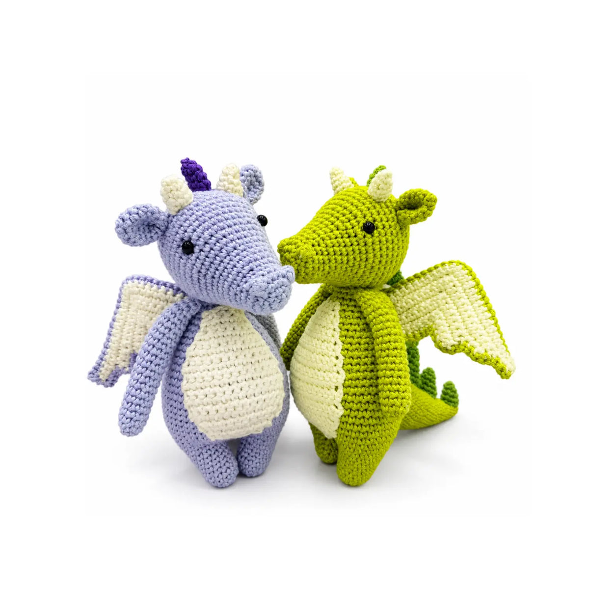 Finished green and lilac crocheted dragons from a DIY dragon crochet kit