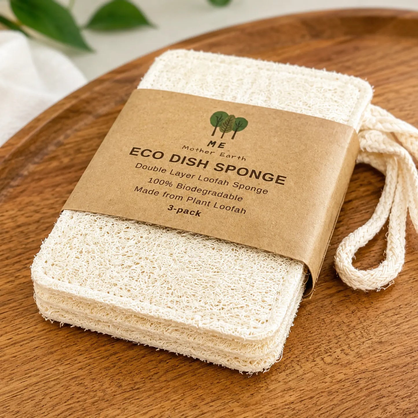 Pack of three double-layer plant loofah dish sponges with cotton hanging loops displayed on a wooden surface.
