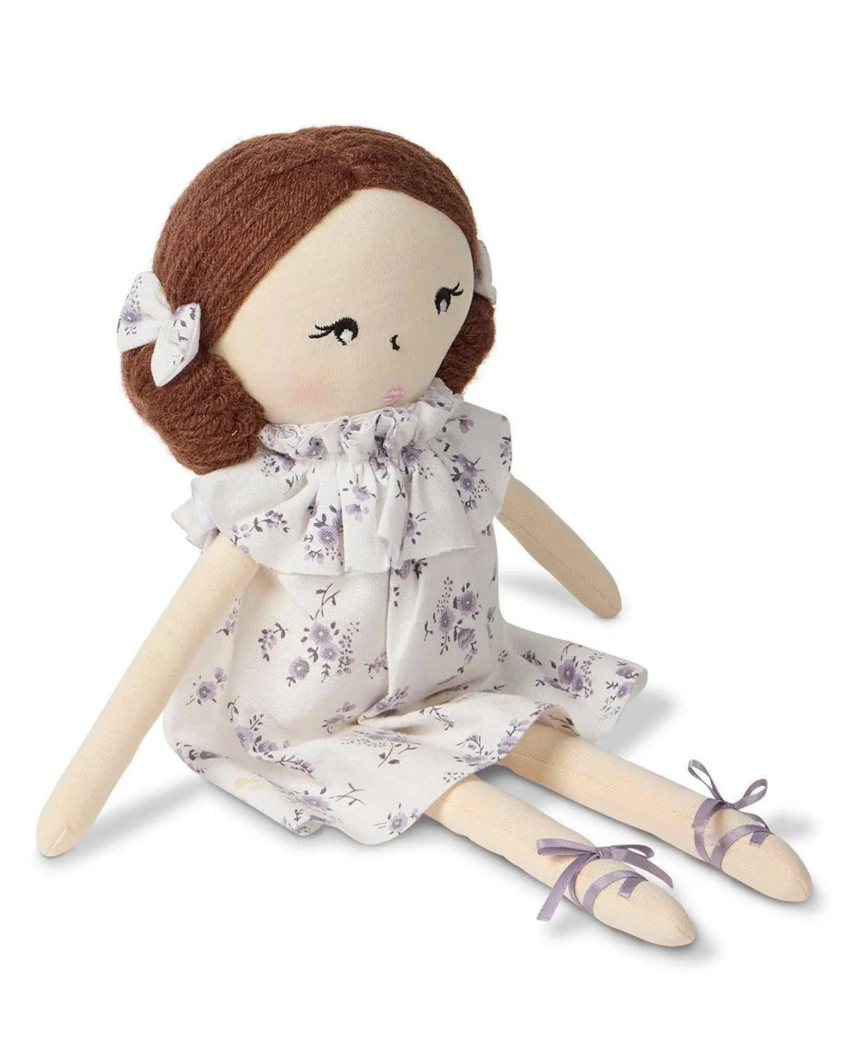 Textile doll with brown hair, floral dress, and ballet shoes on a white background
