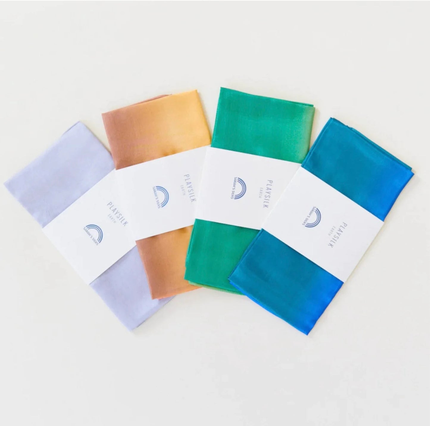 Earth playsilks in stone, desert, forest, and ocean fanned out on a light background