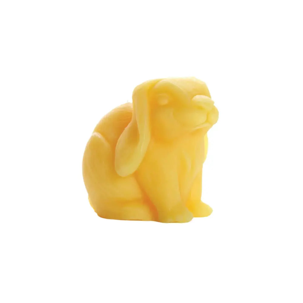 Yellow dog-shaped candle on a white background