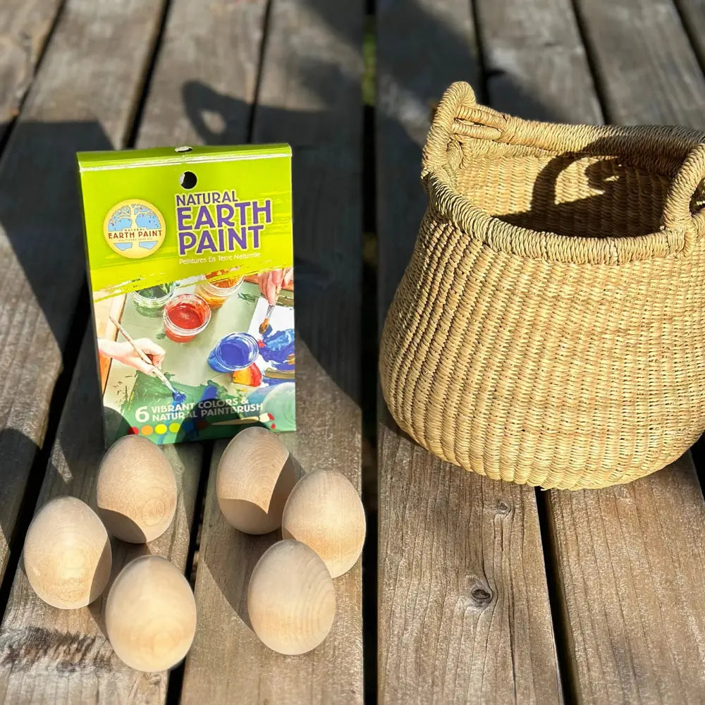 Box of Natural Earth Paint with wooden balls and a woven basket on a wooden surface