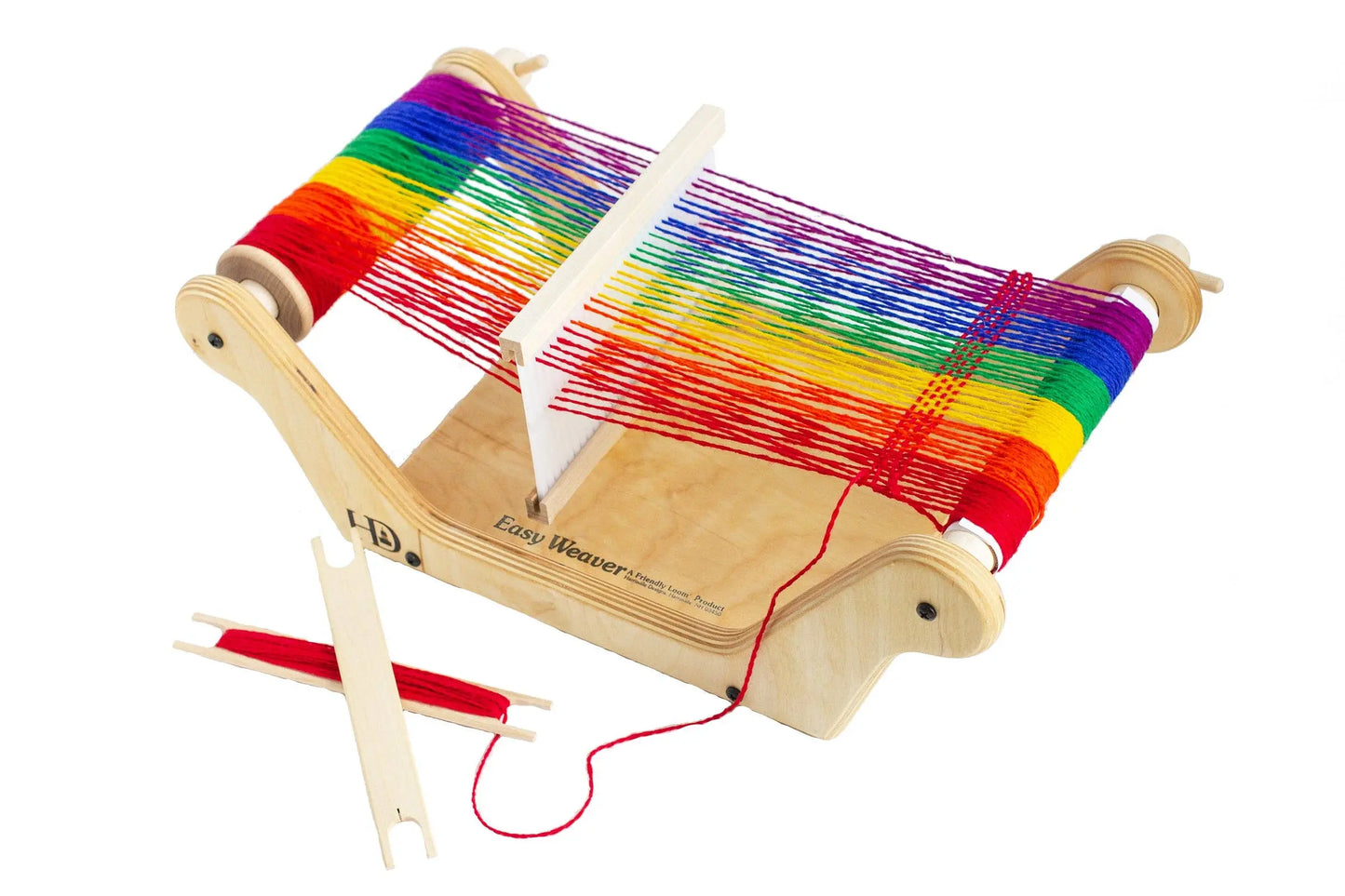 Wooden table loom with rainbow warp, stick shuttles, and red yarn