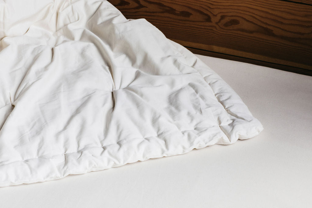 Corner detail of organic wool comforter showing quilted stitching and cotton shell