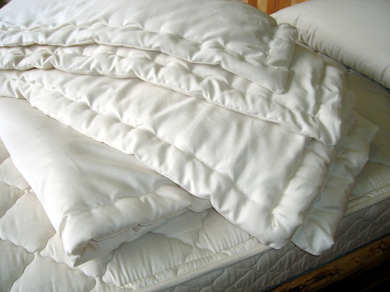 Stacked eco wool comforters showing quilted layers and natural fiber loft