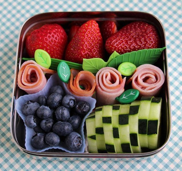 ECOlunchbox Solo Cube packed with strawberries, blueberries, cucumber, and rolled lunch meat