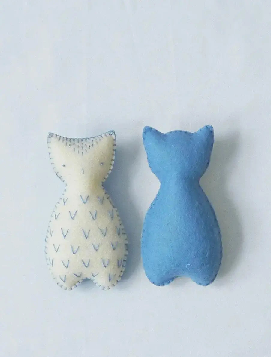 Two blue and white pocket pal owls on a light gray background.