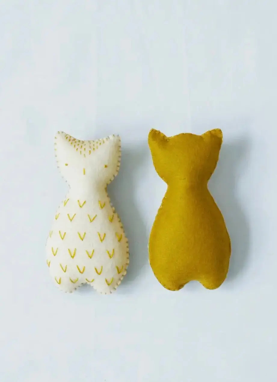 Two ochre and white pocket pal owls from a beginners hand sewing kit