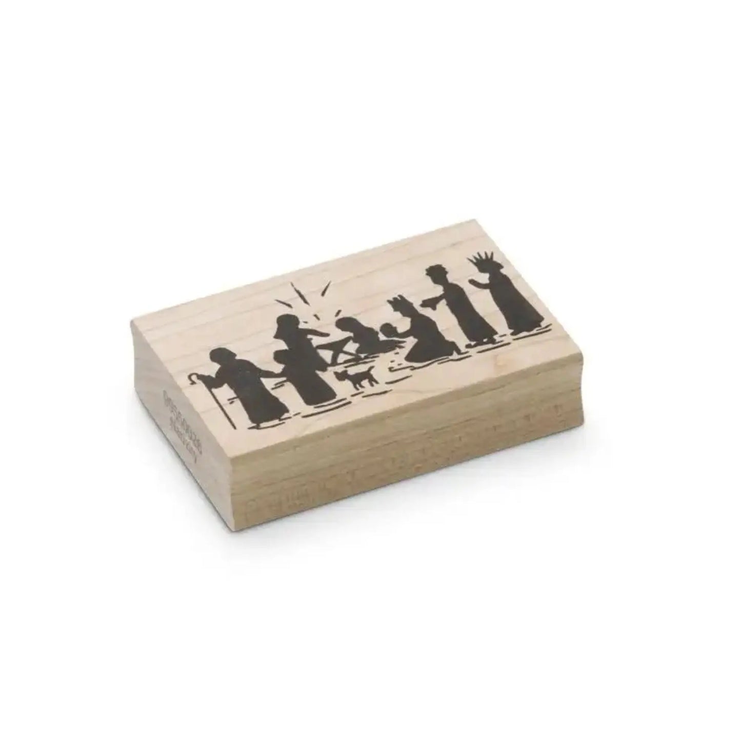 Wooden stamp block with black silhouettes of the nativity scene on hite background