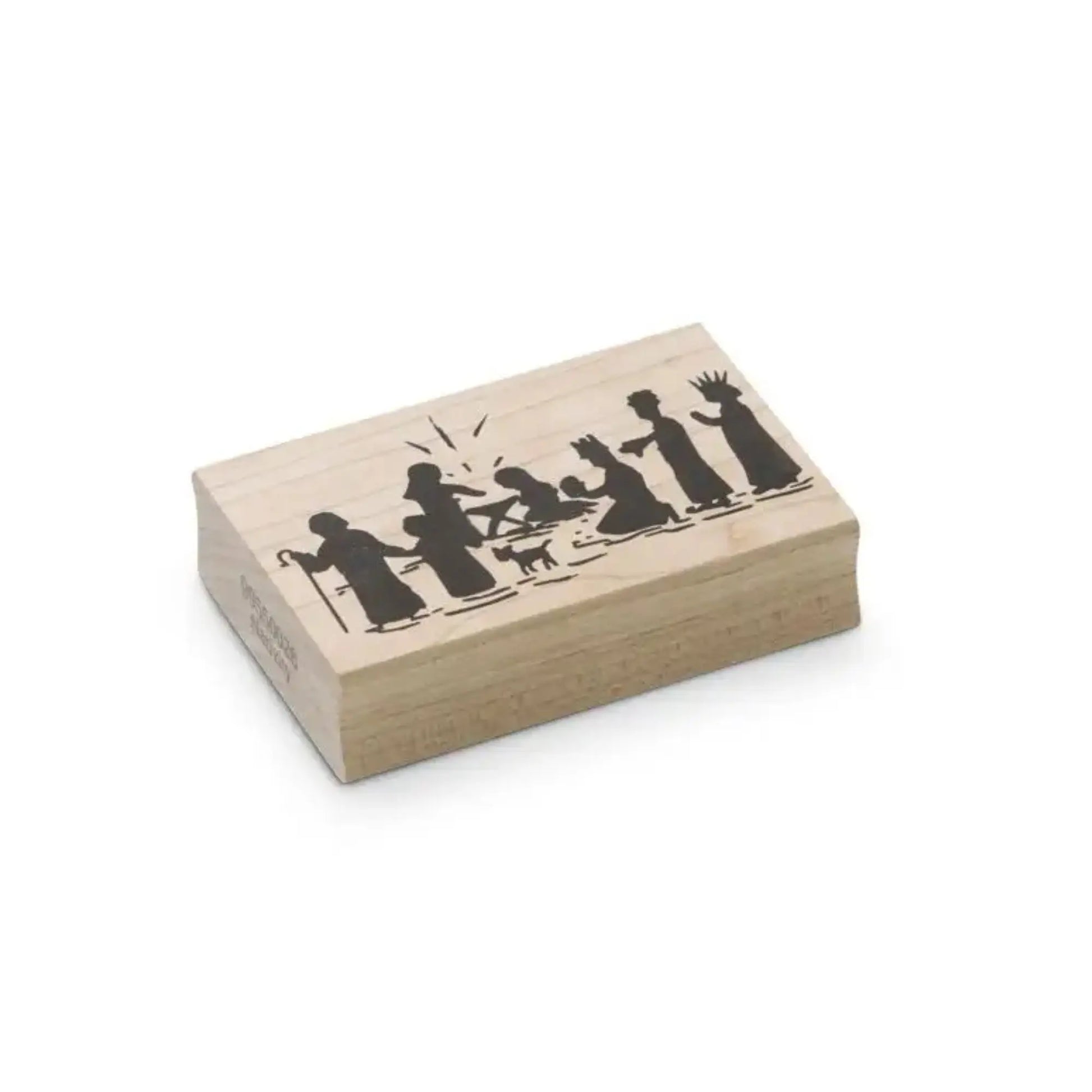 Wooden stamp block with black silhouettes of the nativity scene on hite background
