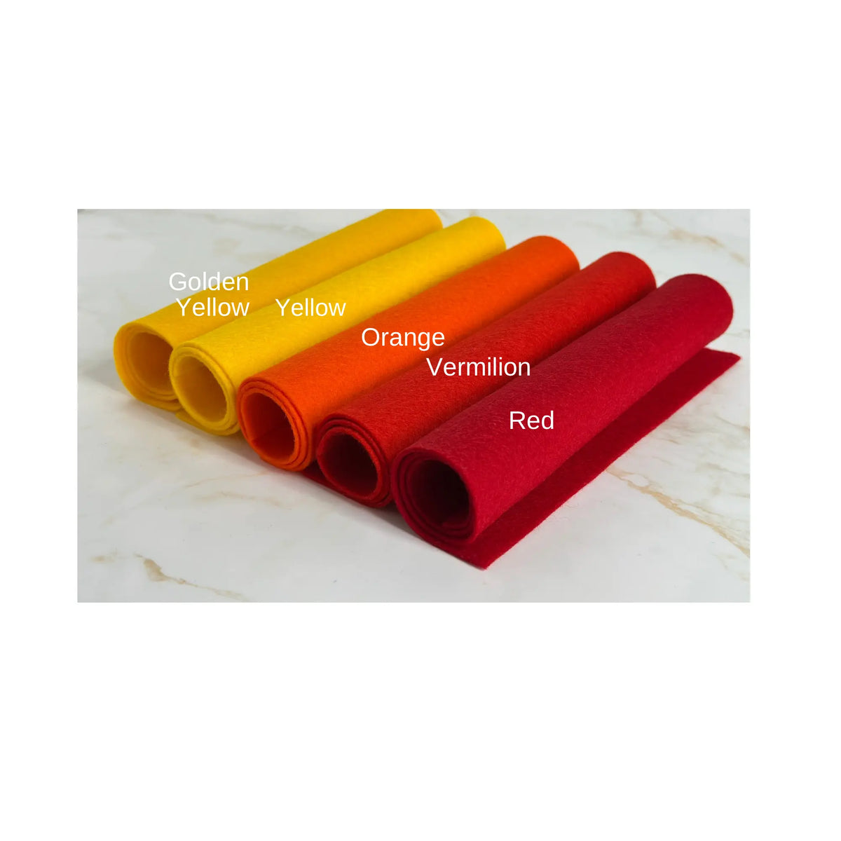 100% Wool Felt rolls on a marble surface showing the colors golden yellow, yellow, orange, vermilion, and red