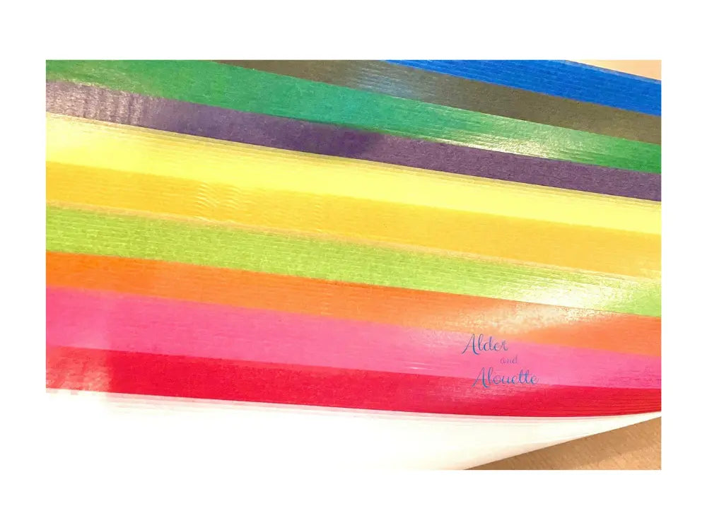 Colorful striped kite paper with Alder & Alouette branding on a white background