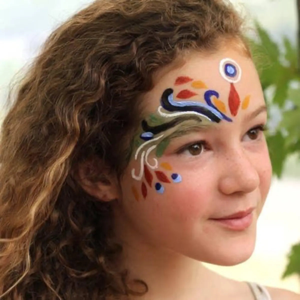 Young girl with colorful face paint against a natural background