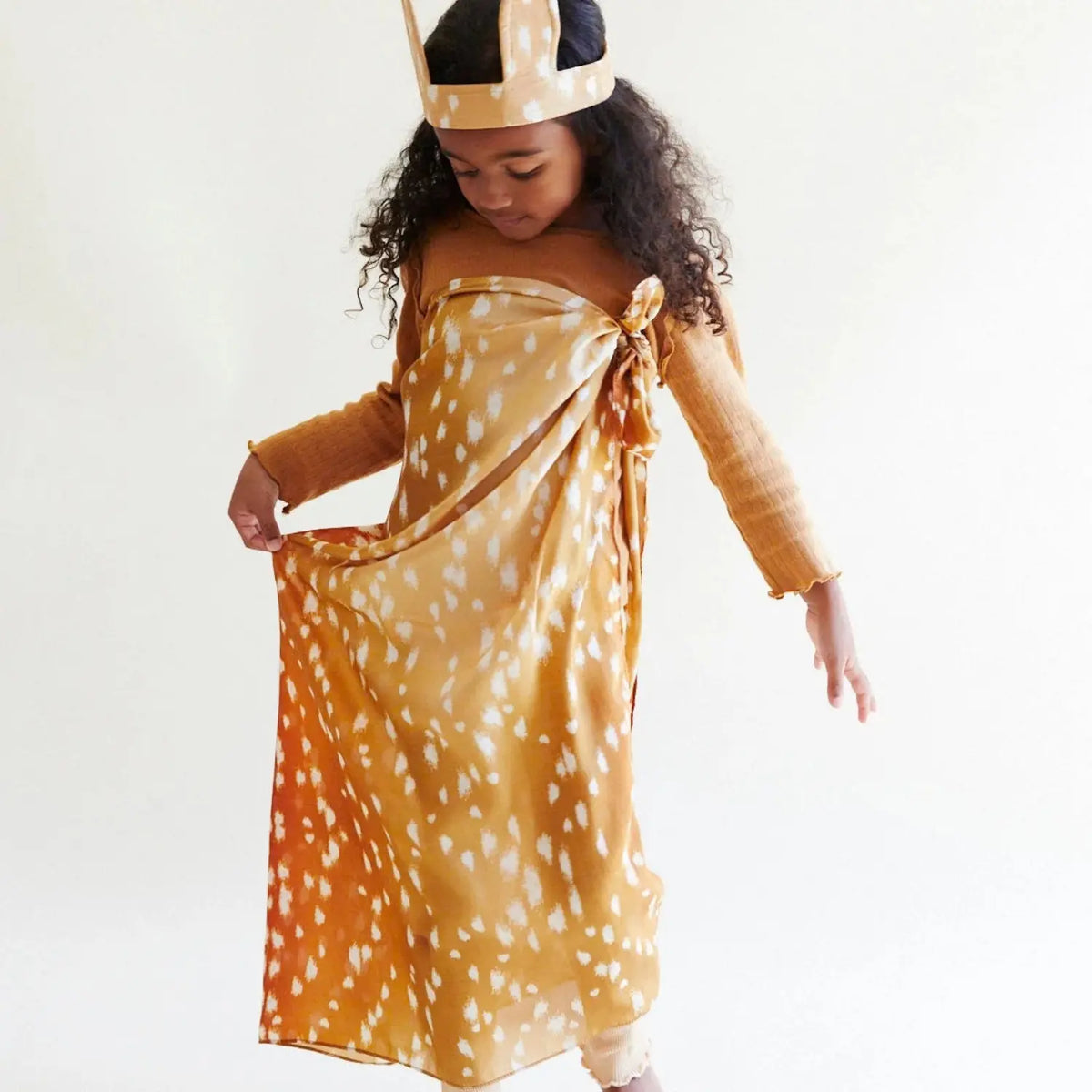 Child wearing a fawn-print Playsilk as a dress for imaginative play