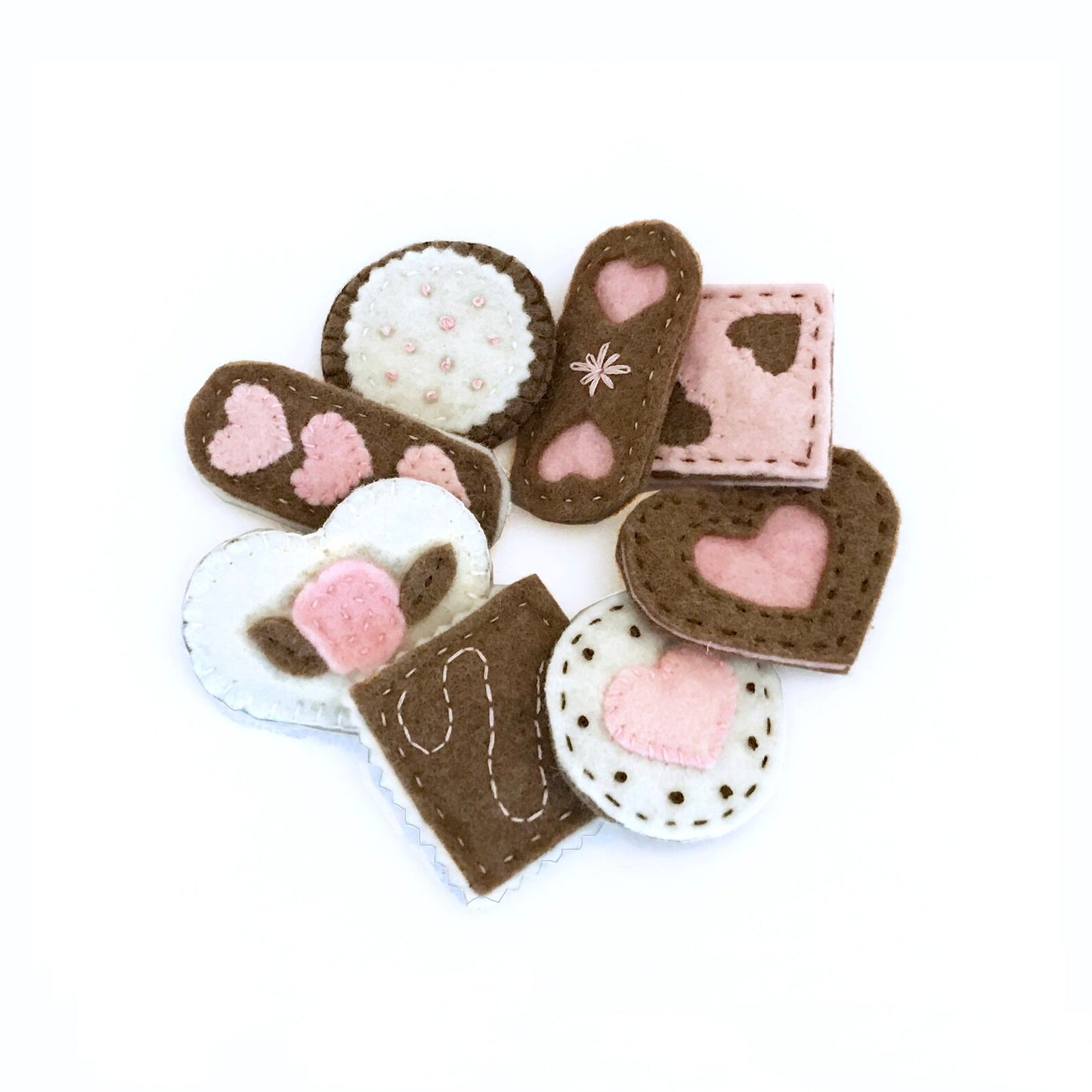 Felt cookies with heart designs on a white background