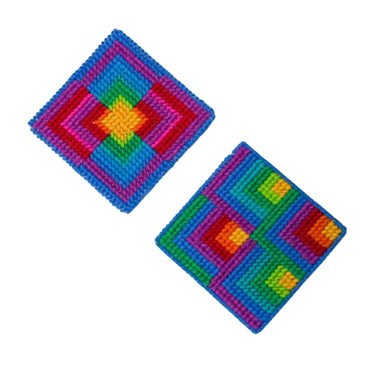 Two finished 4-inch needlepoint coasters stitched in rainbow wool with nested color blocks and blue borders