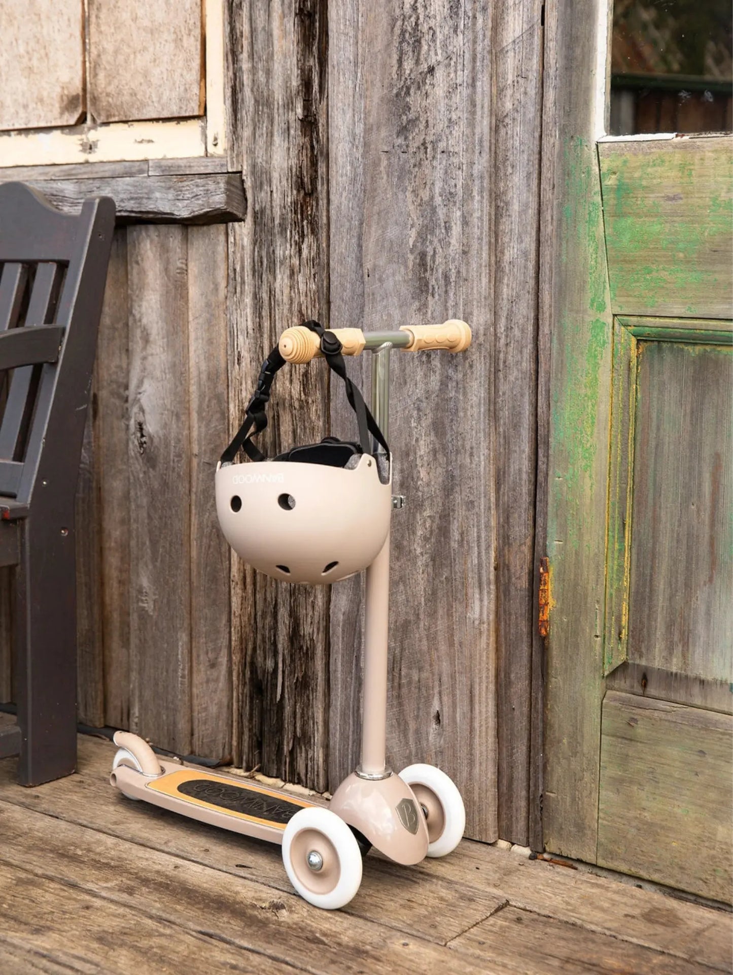 Child's scooter with helmet hanging on a wooden wall