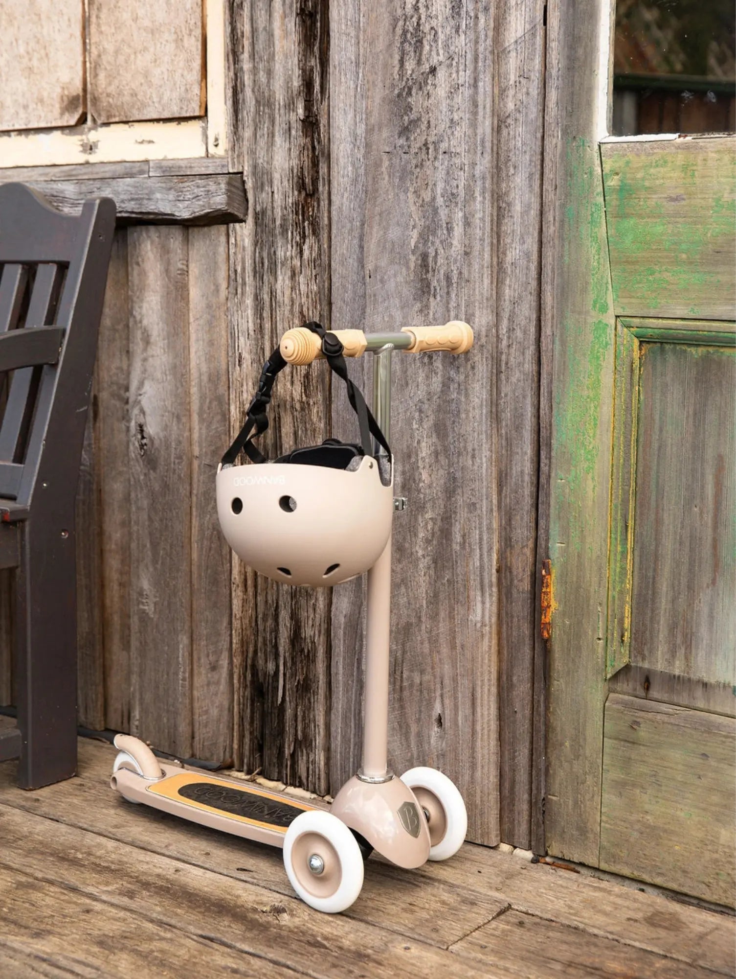 Child's scooter with helmet hanging on a wooden wall