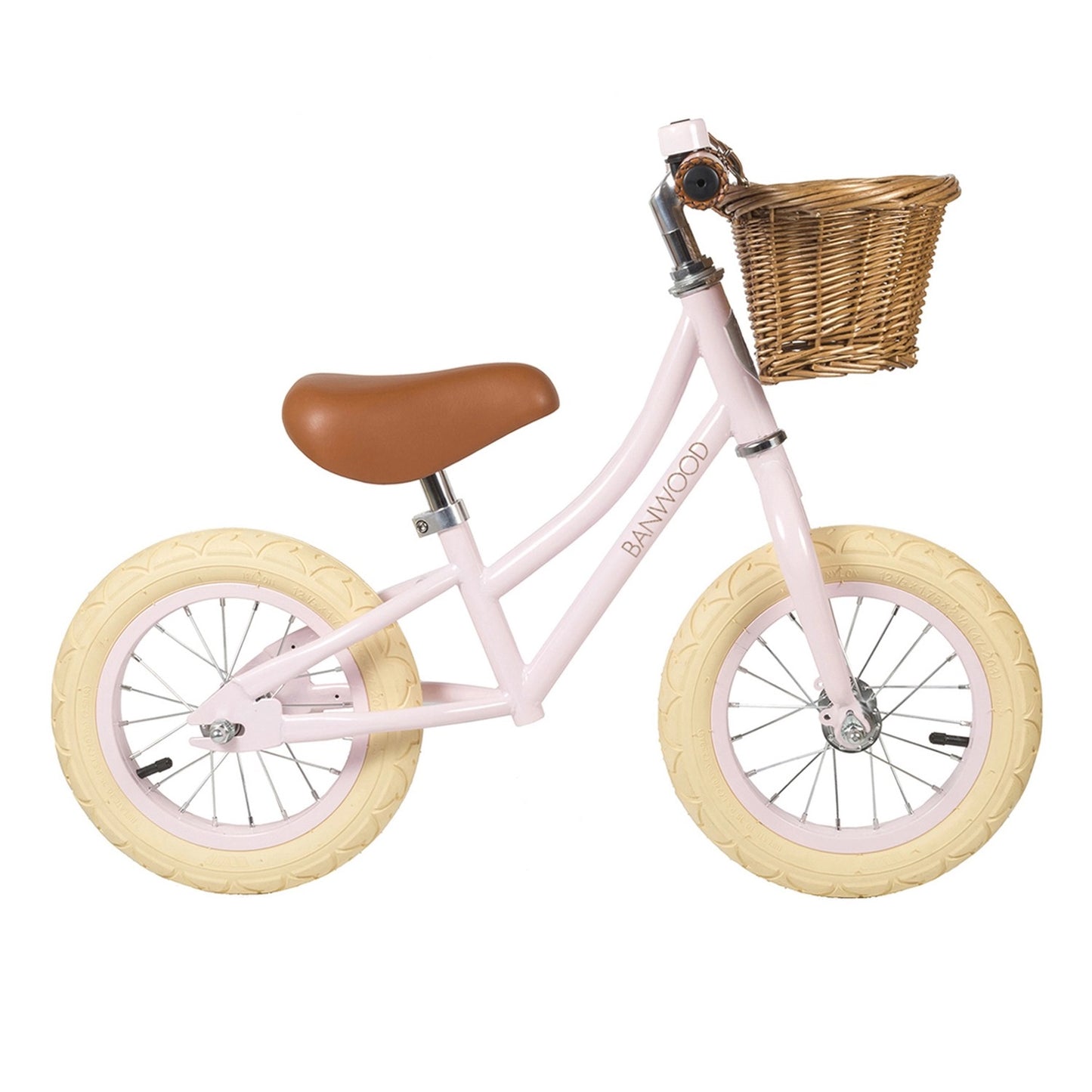 Pink balance bike with a wicker basket on a white background