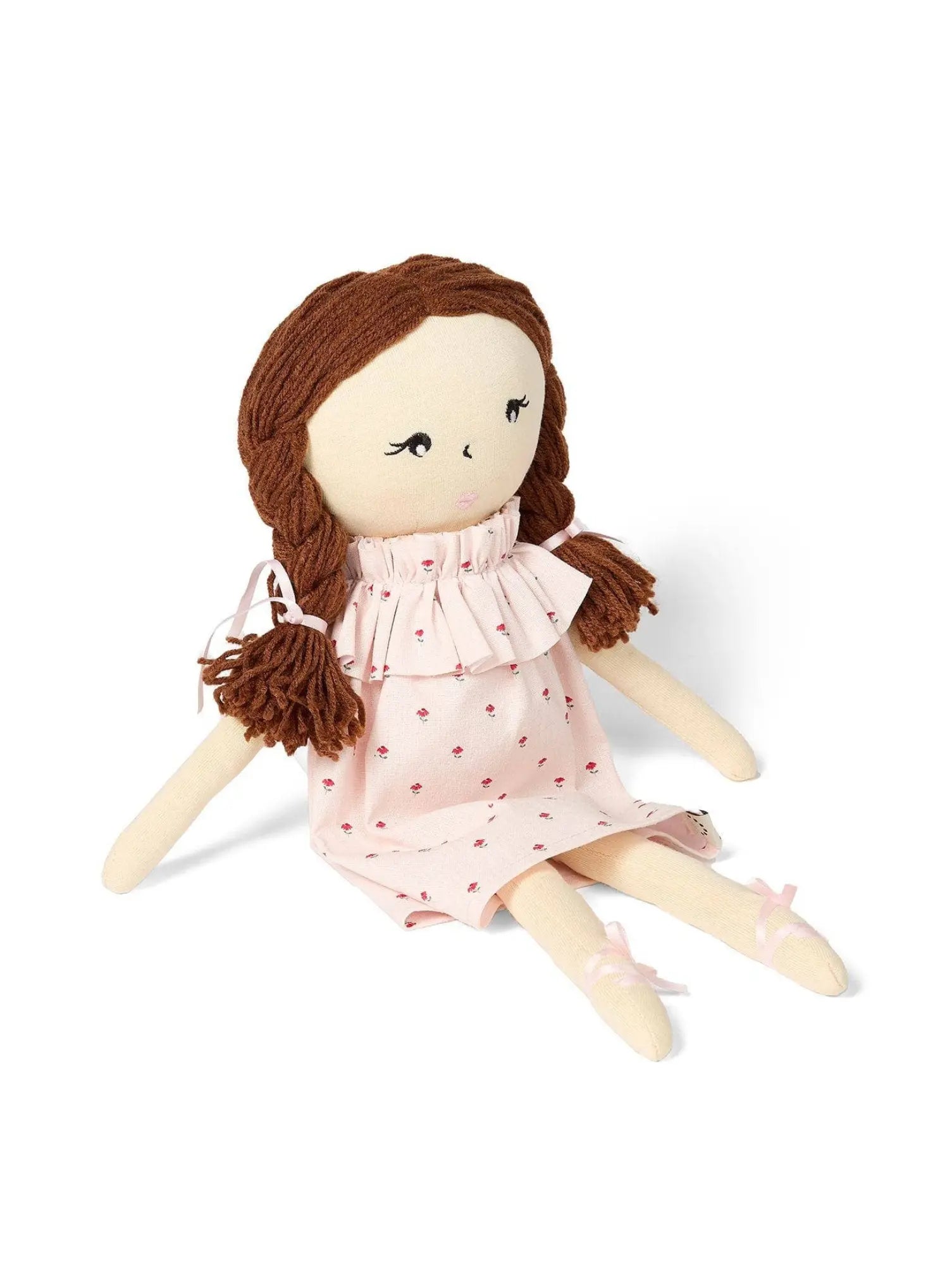 Fabric doll with brown hair and a pink dress on a white background