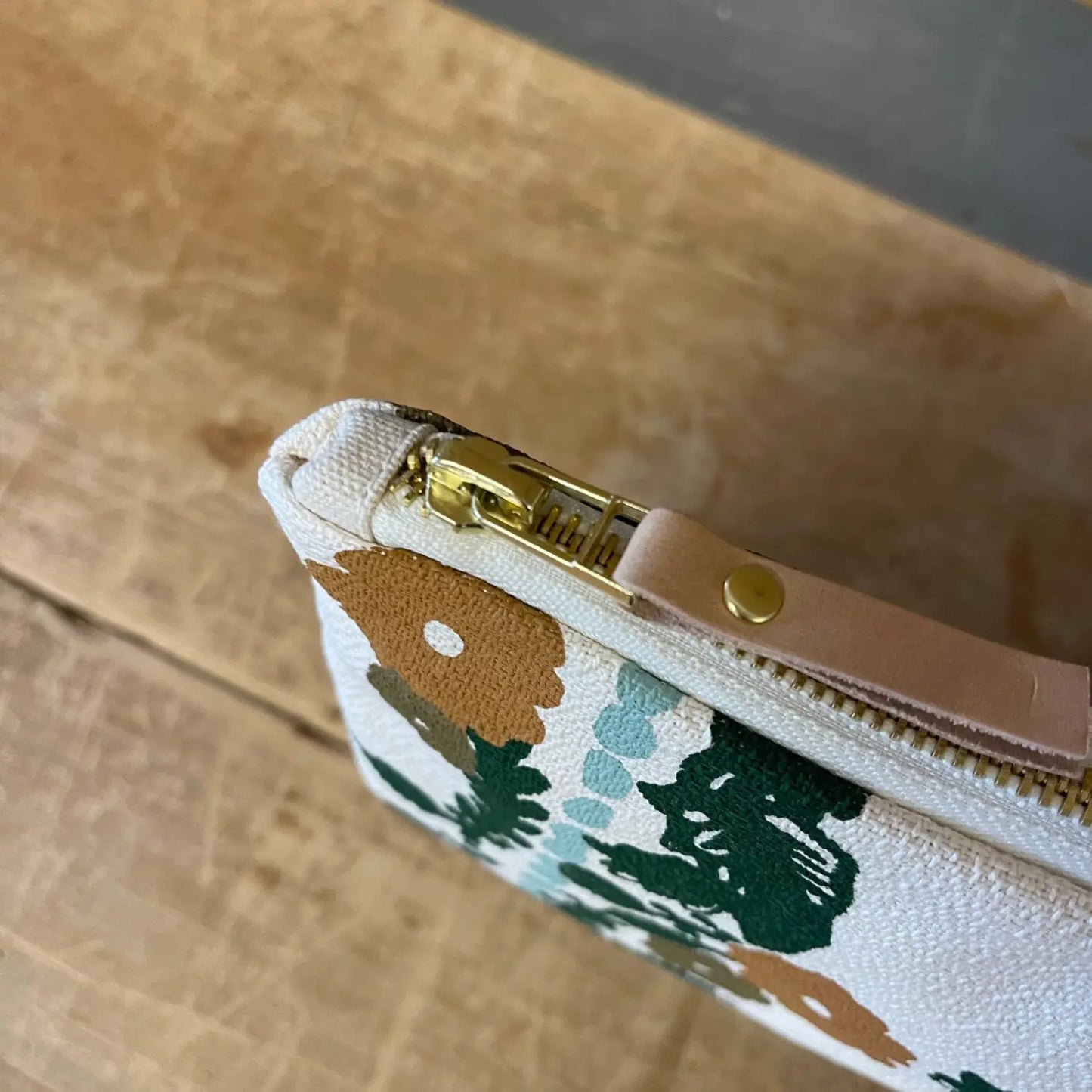 Close-up of the brass zipper and leather pull on the Erin Flett Folklore pencil bag