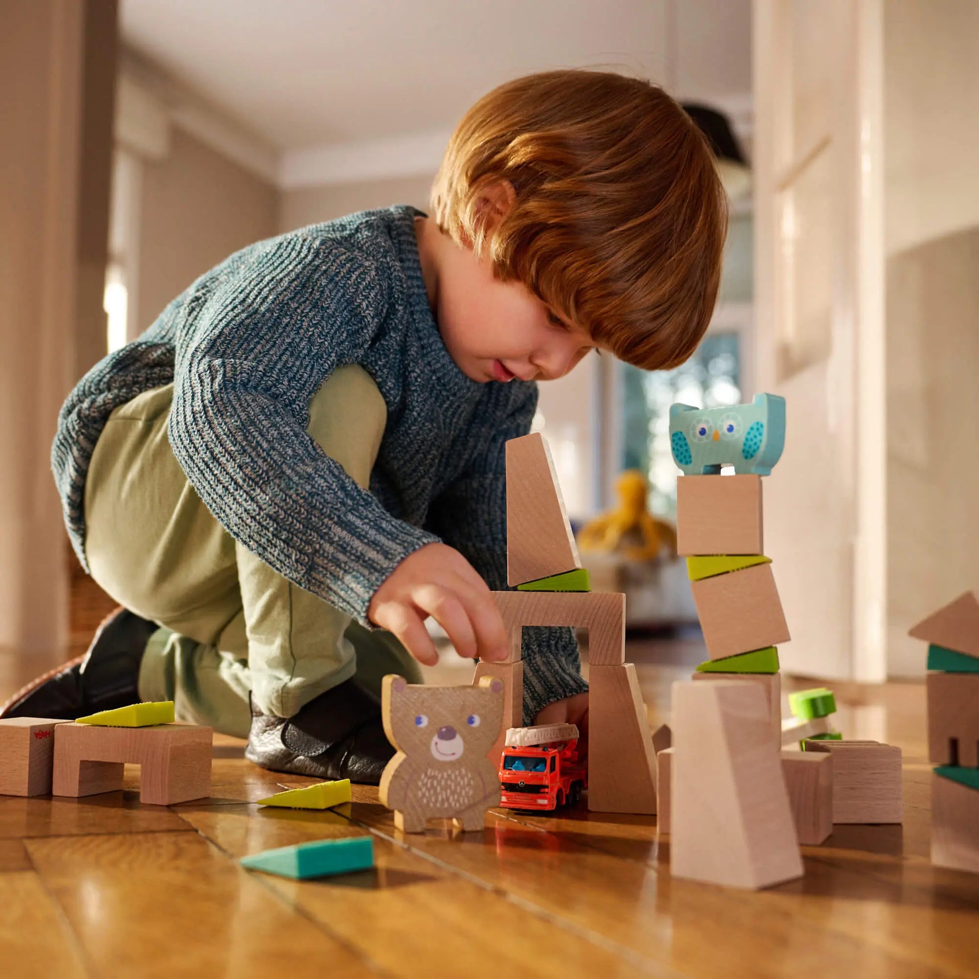 Child playing with wooden toys on a wooden floor