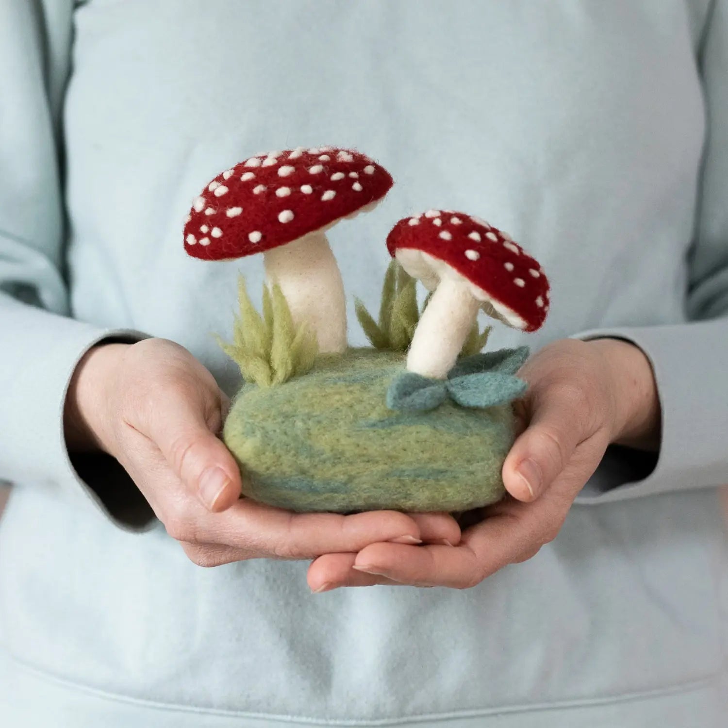Finished Forest Toadstools needle felted mushroom scene held in two hands for scale