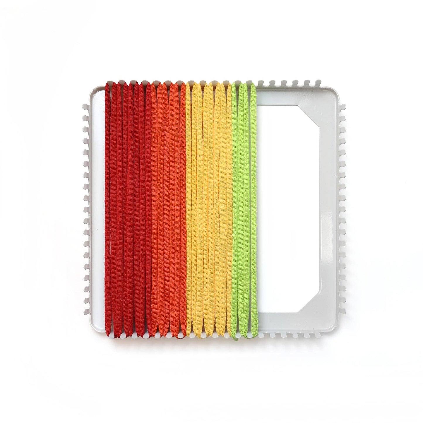 Rainbow cotton loops stretched across a metal potholder loom for weaving