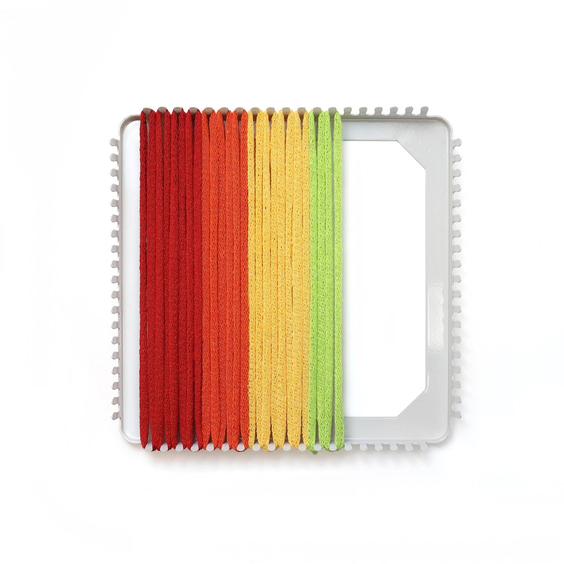 Rainbow cotton loops stretched across a metal potholder loom for weaving