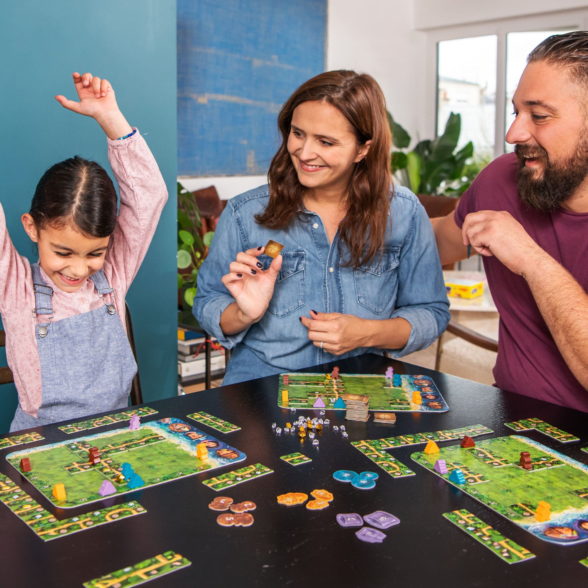 Family playing a board game together in a cozy living room.