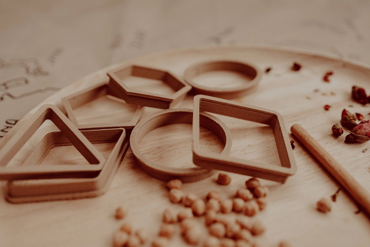 Wooden letter stamps on a wooden surface with scattered seeds.