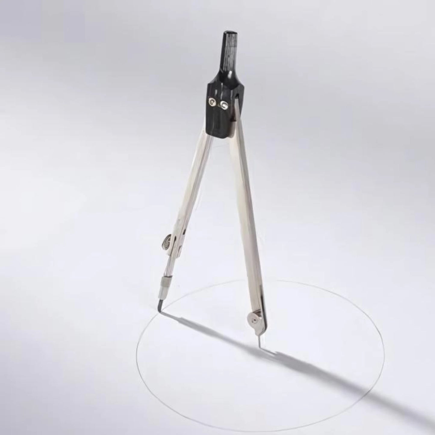 Metal School Compass drawing a circle on a grayish white background 