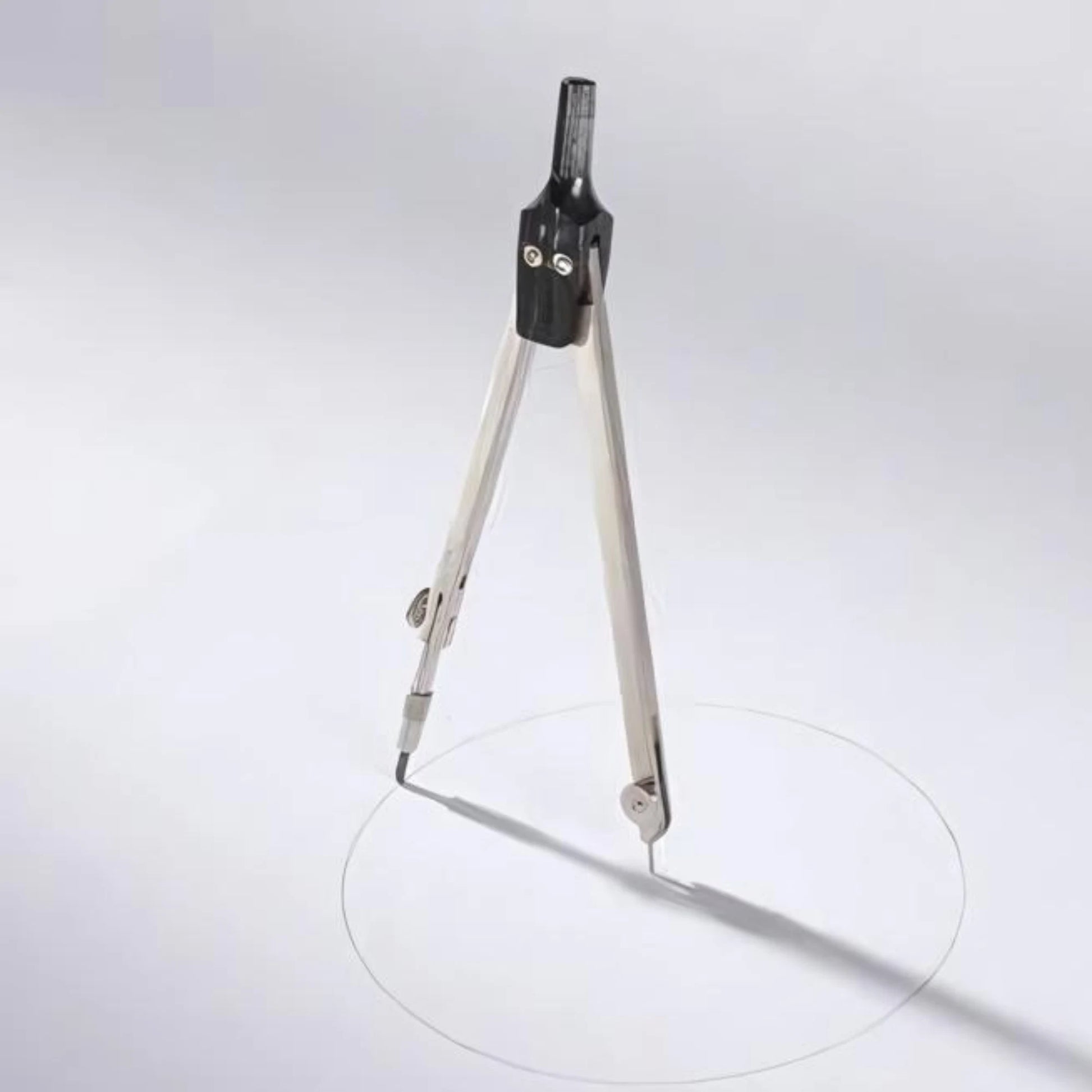 Metal School Compass drawing a circle on a grayish white background 