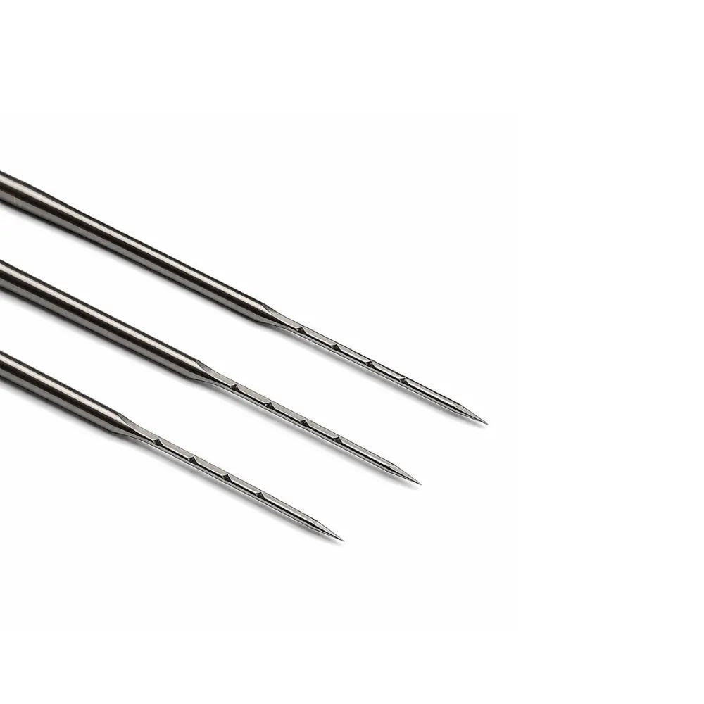 Close up of three metallic felting needles on a white background