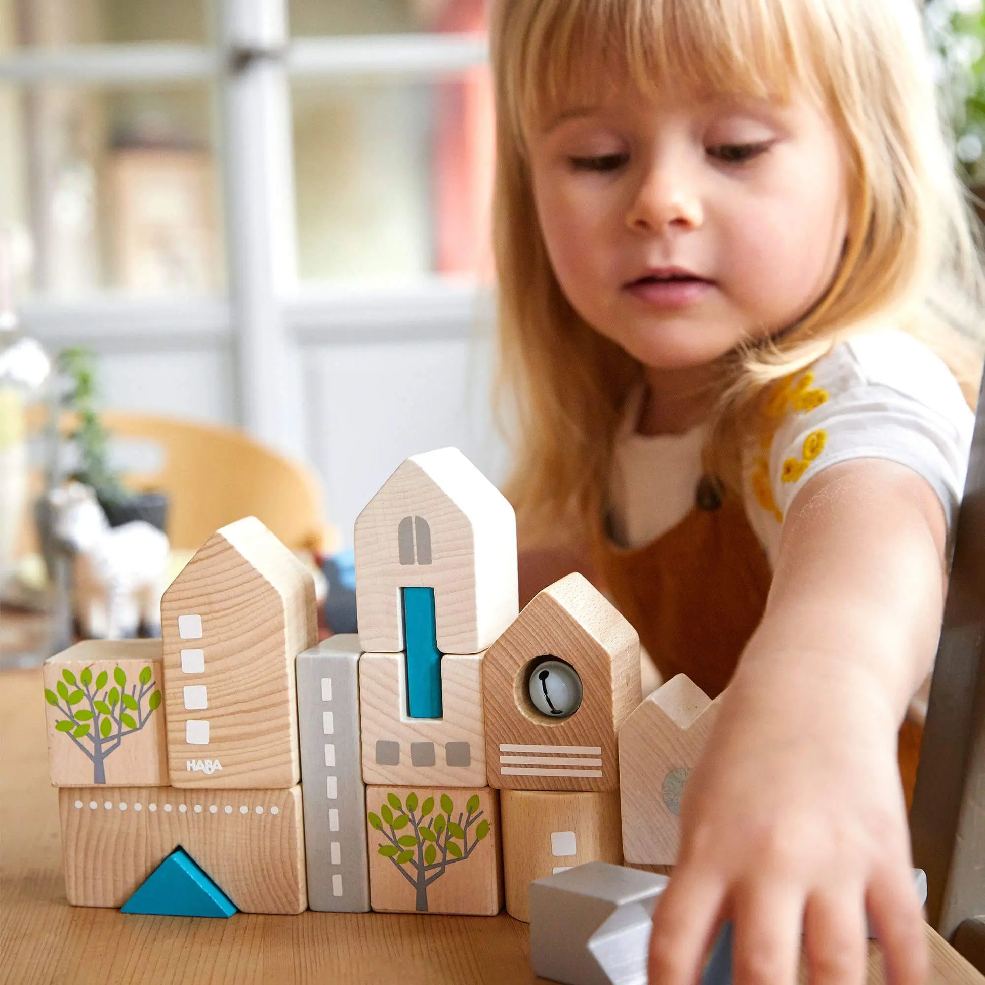 Preschooler building with HABA Bad Rodach wooden blocks, sustainable German wooden toy for creative, open-ended play