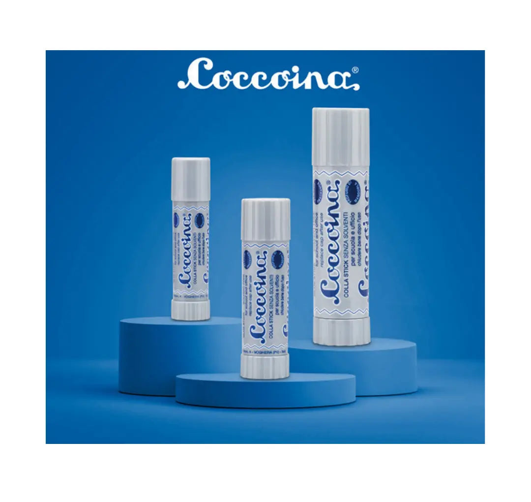 Three sizes Coccoina glue sticks in gray tubes on a blue background