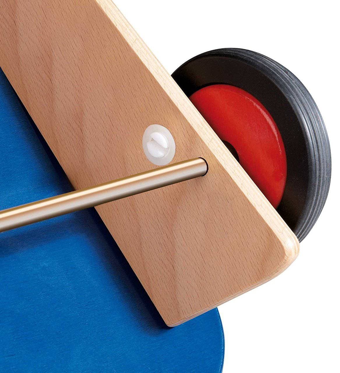 Close-up of a wooden clock with a red and black interior on a blue background