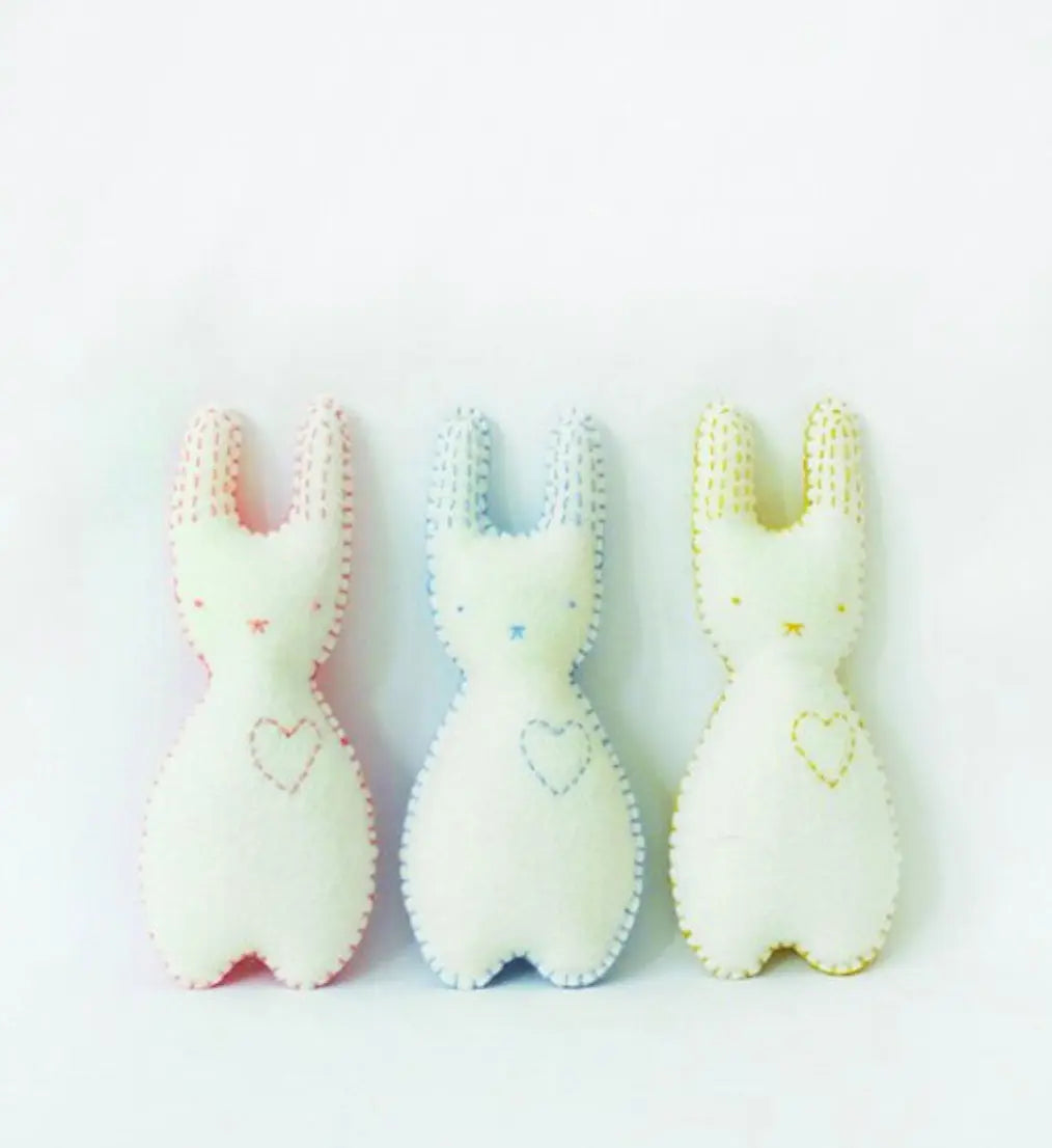 Three soft pocket pal bunnies in pastel colors on a white background