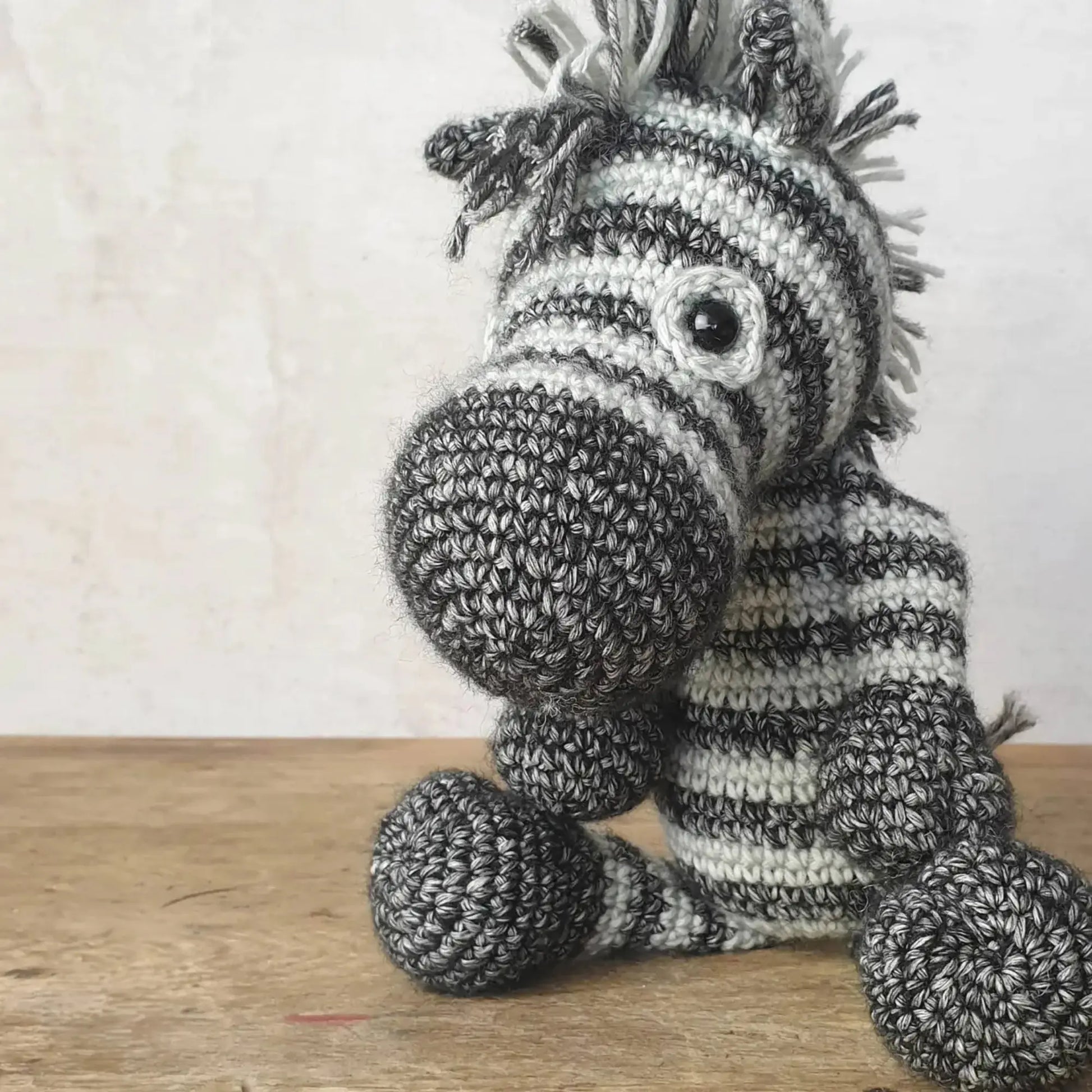 Handmade crocheted zebra soft toy with black and gray stripes