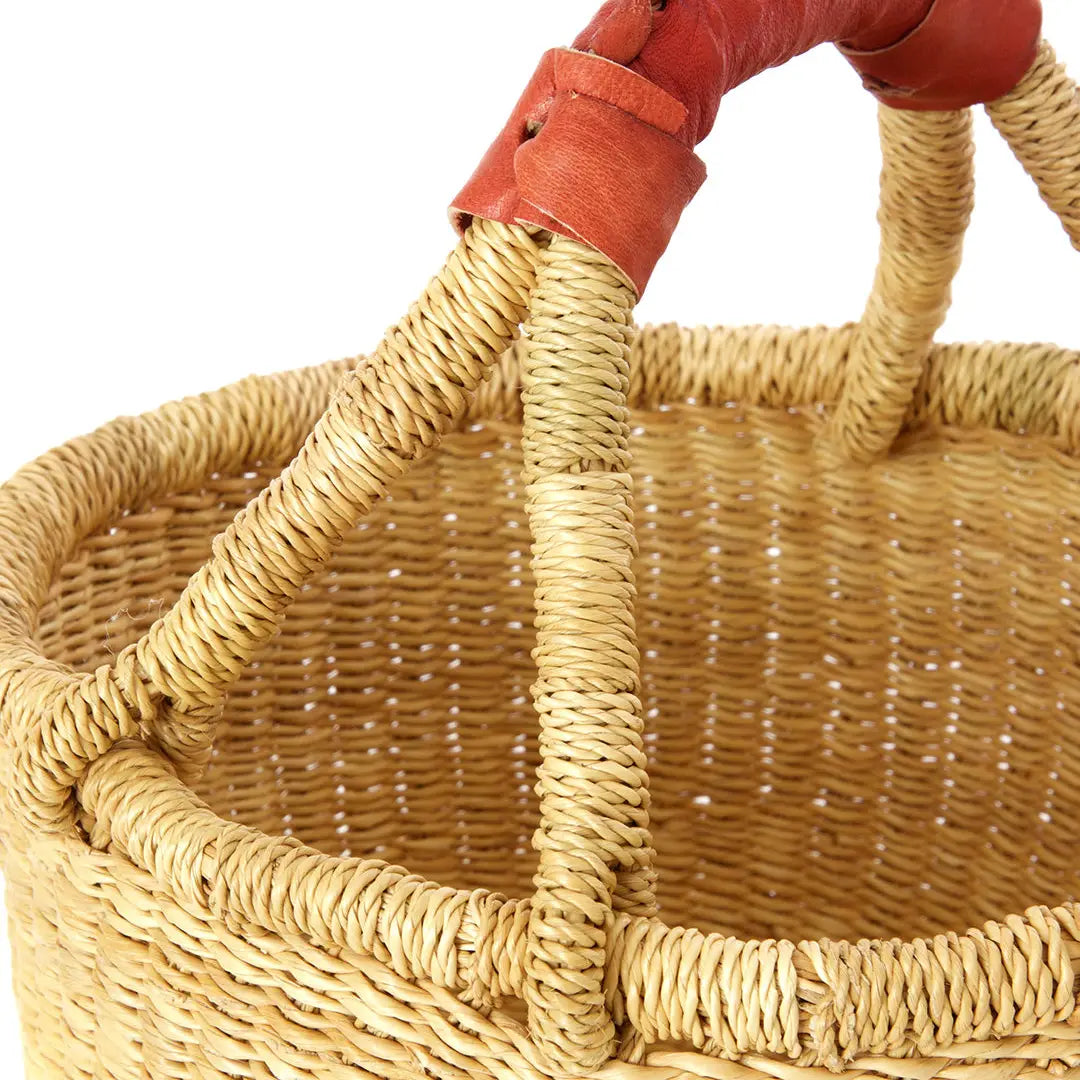 Wicker basket with a red handle on a white background