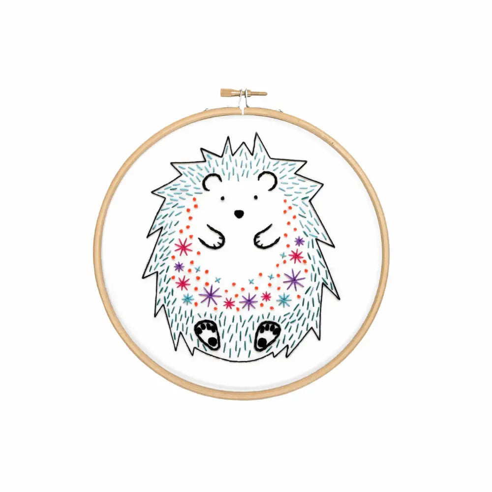 Embroidery hoop with a cartoon hedgehog design on a white background