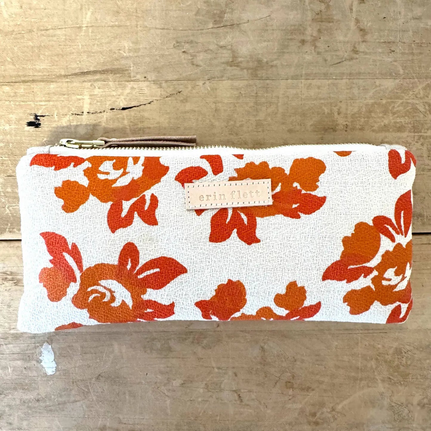 Cotton barkcloth pencil bag in orange floral by Erin Flett on a wooden background