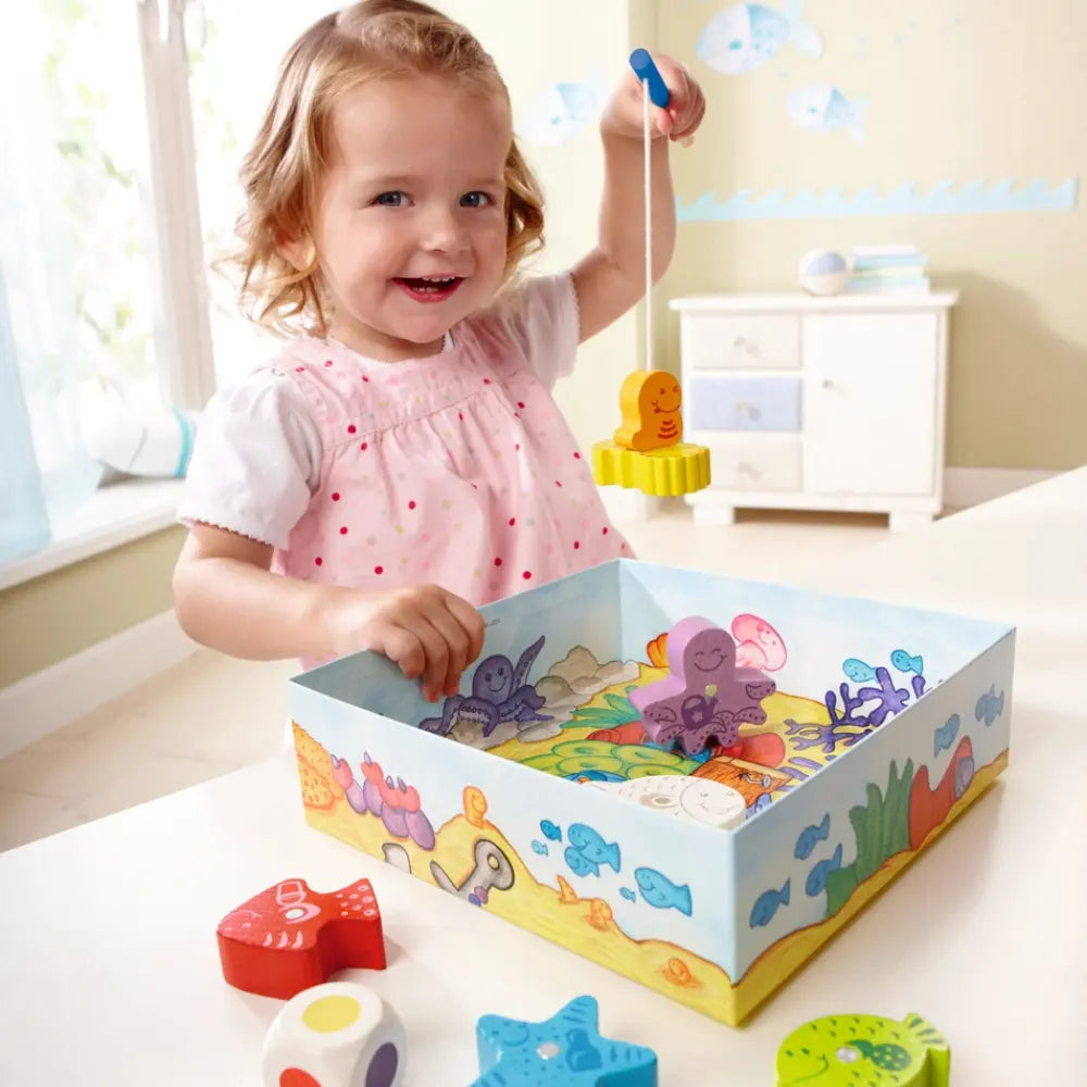 Toddler using magnetic fishing rod in Here Fishy Fishy game