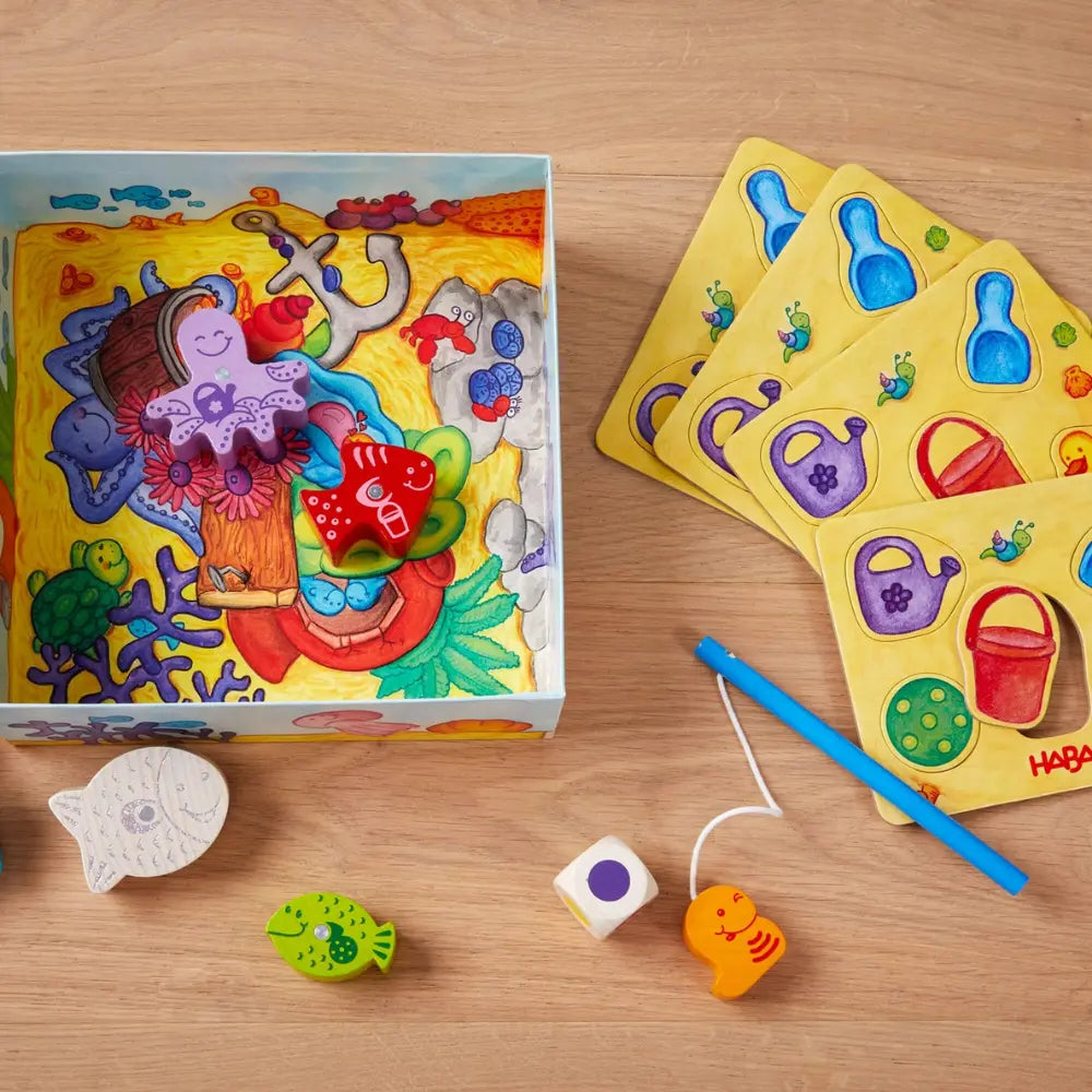 Here Fishy Fishy game components with wooden fish, magnetic rod, and die