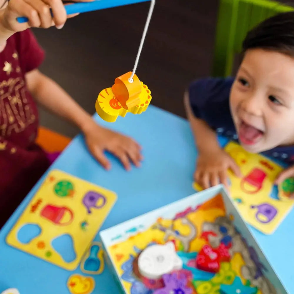 Young children playing Here Fishy Fishy magnetic fishing game together