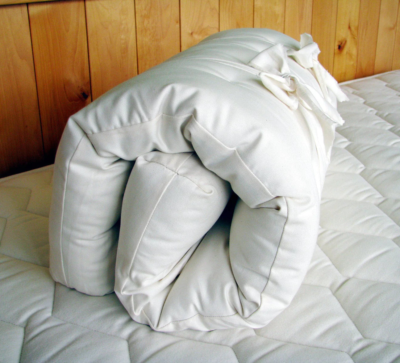  Natural Wool bassinet mattress rolled up on top of another mattress