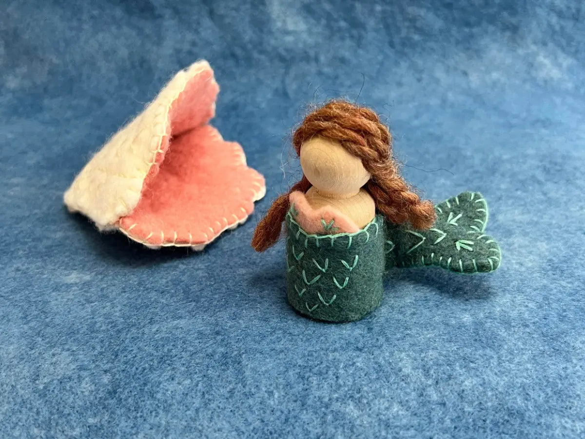 Mermaid figurine with a shell on a blue background